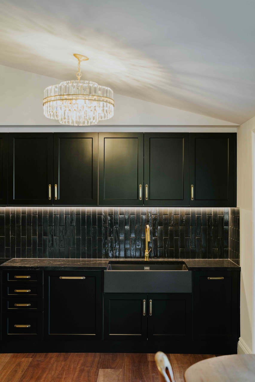 The all-black kitchen — one of the house's more unexpected design choices.